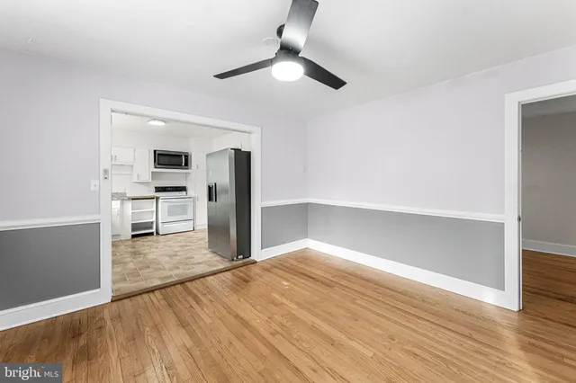 wooden floor in an empty room with a kitchen