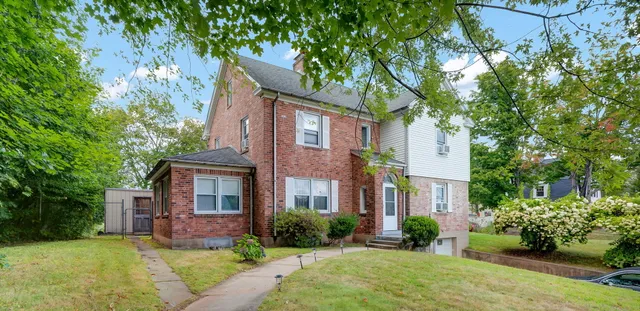a front view of a house with a yard and potted plants