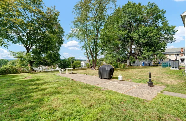 a view of a house with a yard and a fountain