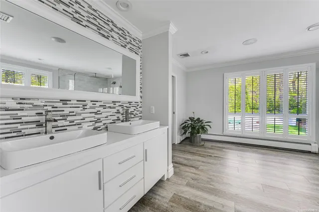 a bathroom with a double vanity sink and a large mirror