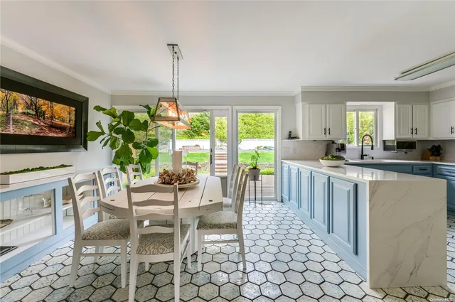 a living room with furniture a flat screen tv and a dining table