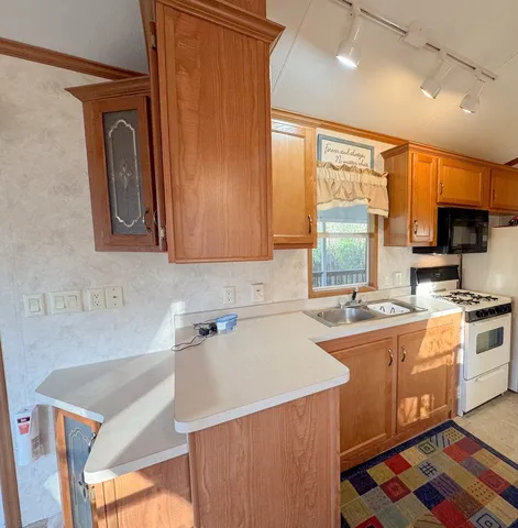 a kitchen with stainless steel appliances granite countertop a sink a stove and a refrigerator