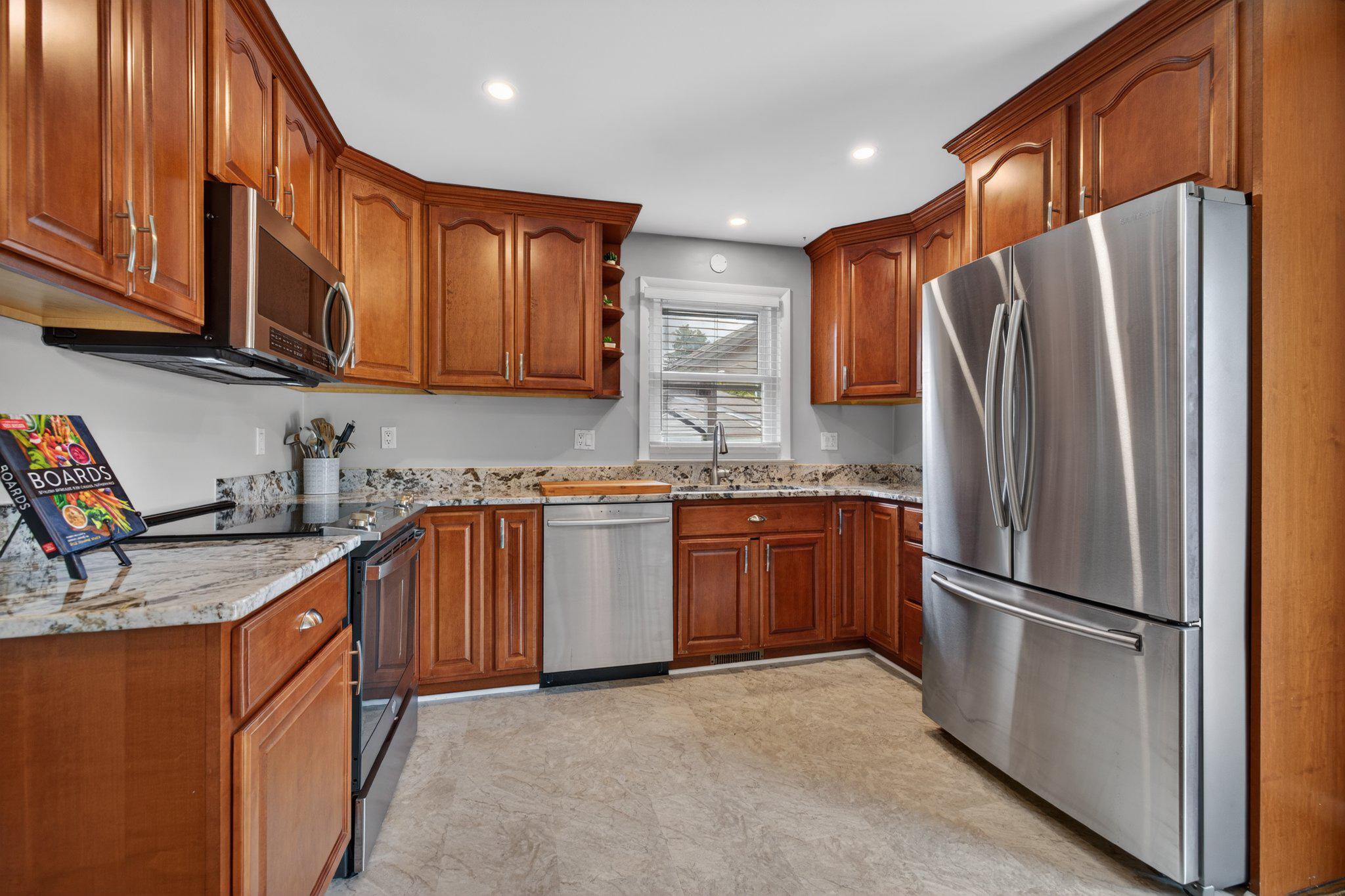 1002 Wilson Place Frederick, MD 21702 - Photo 7 of 30 a kitchen with stainless steel appliances granite countertop a refrigerator stove and sink