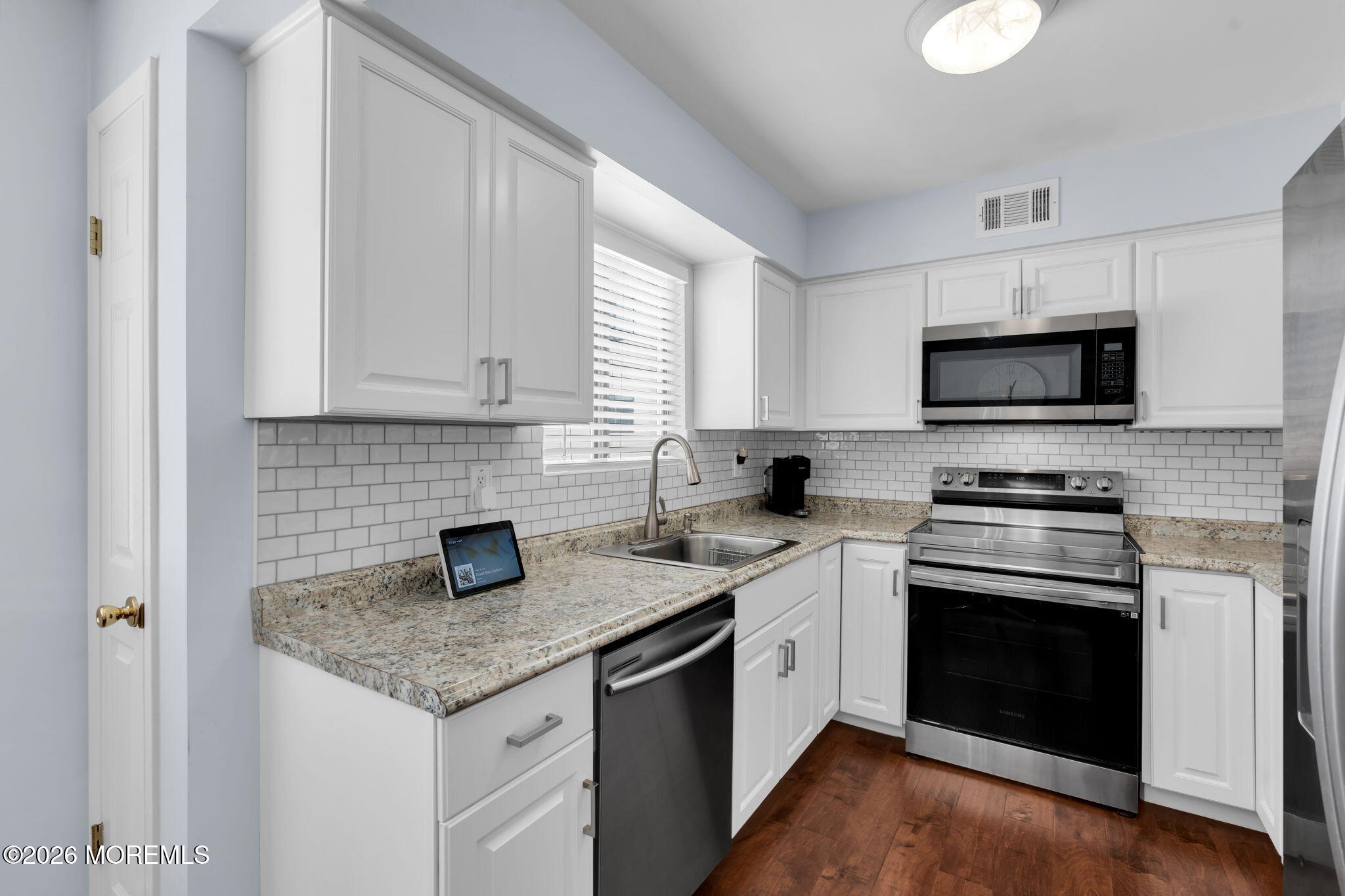 375 Middlewood Road Middletown, NJ 07748 - Photo 10 of 36 a kitchen with granite countertop white cabinets and a stove with wooden floor