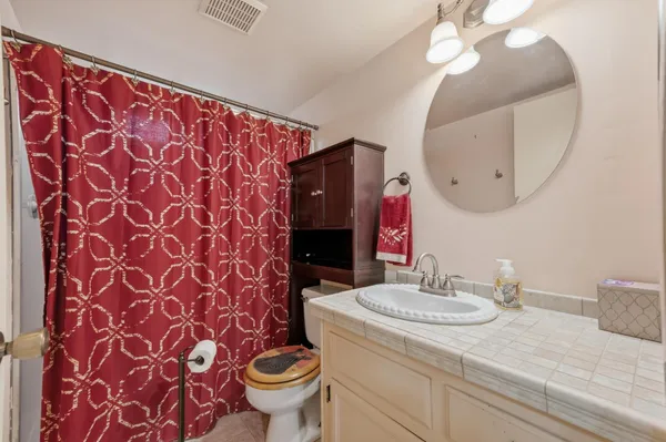 a bathroom with a sink and a mirror with toilet