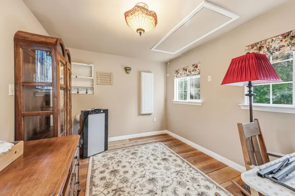a view of a bedroom with wooden floor and a window