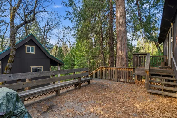 a backyard of a house with barbeque oven and trees