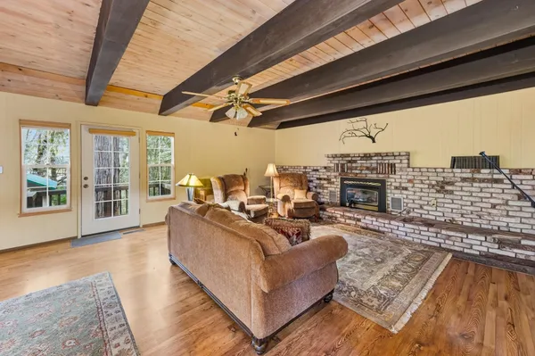 a living room with furniture a fireplace and a floor to ceiling window