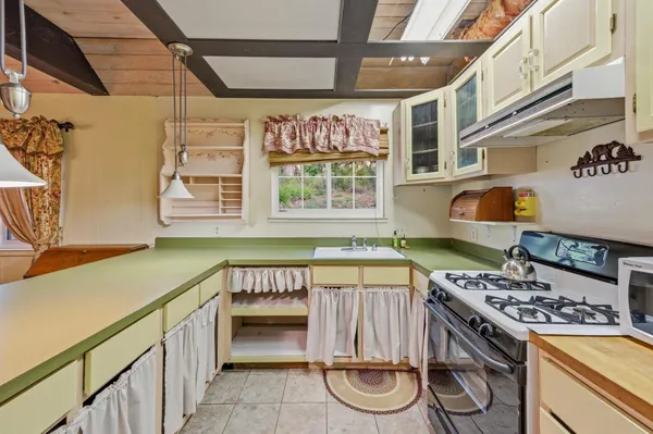 a kitchen with a stove and a white wooden cabinets