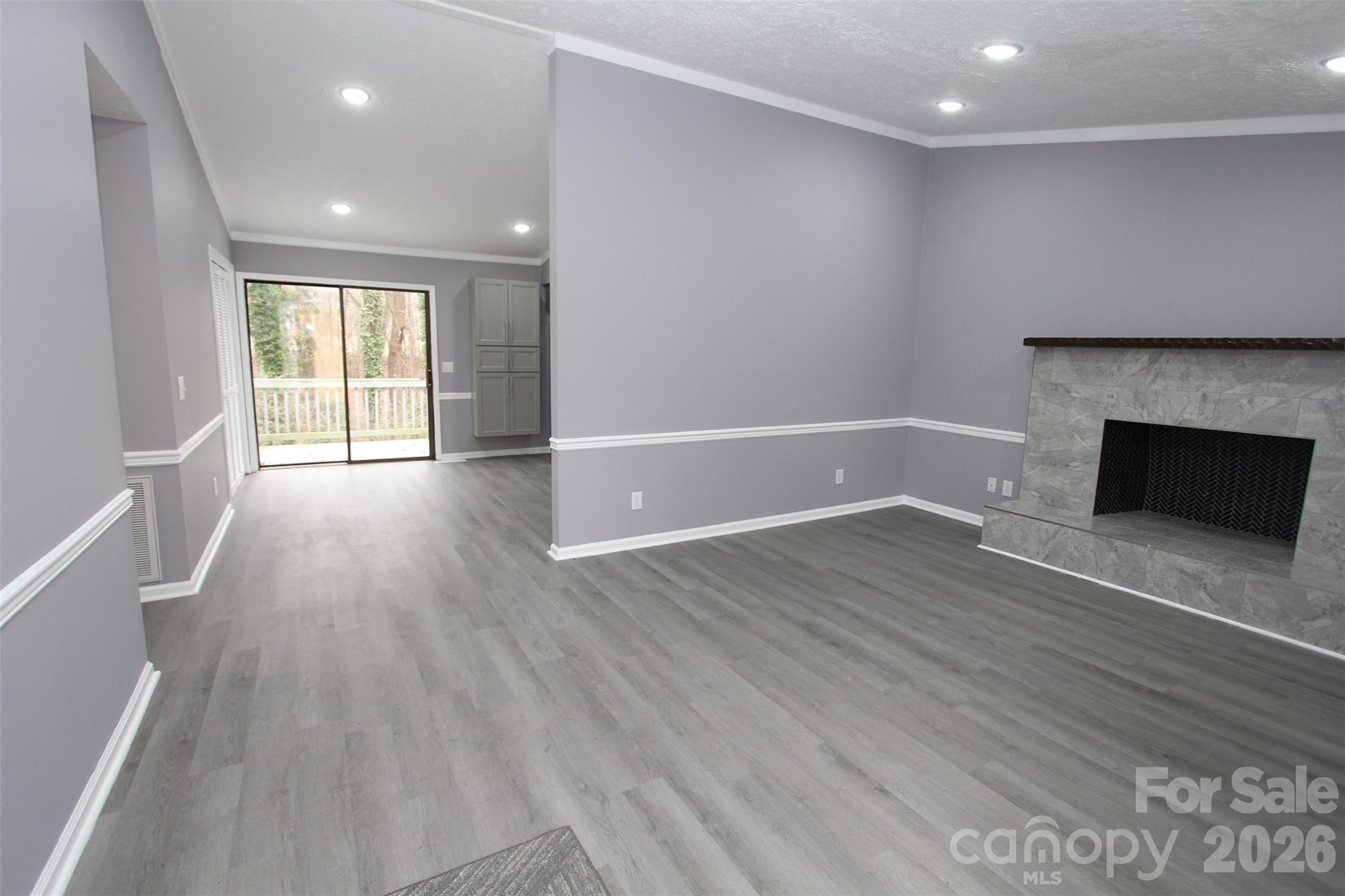 48 Piper Road Wadesboro, NC 28170 - Photo 5 of 34 an empty room with wooden floor and fireplace