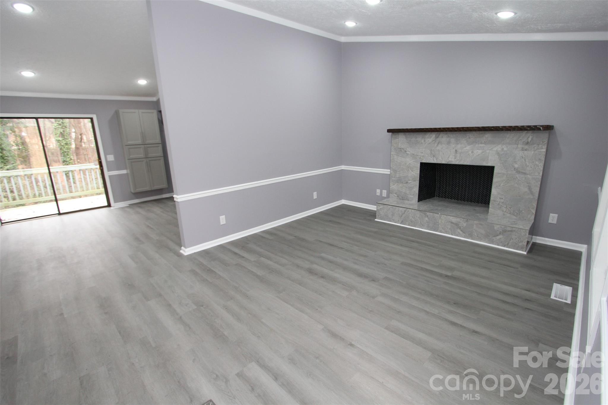 48 Piper Road Wadesboro, NC 28170 - Photo 7 of 34 an empty room with wooden floor and fireplace