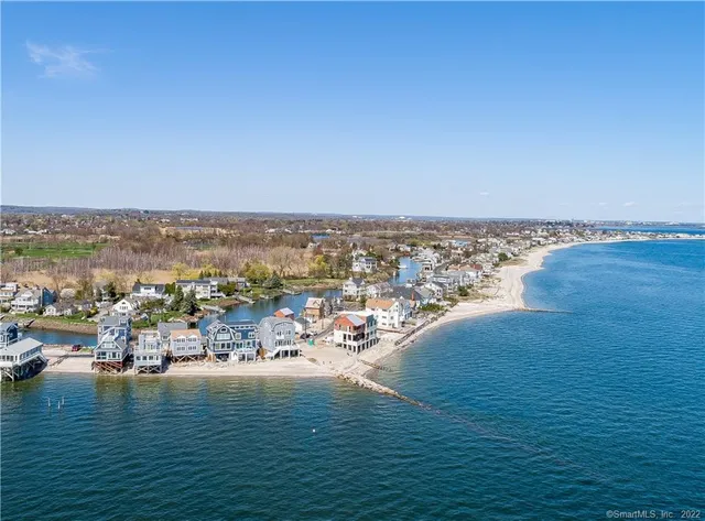 an aerial view of ocean and residential houses with outdoor space