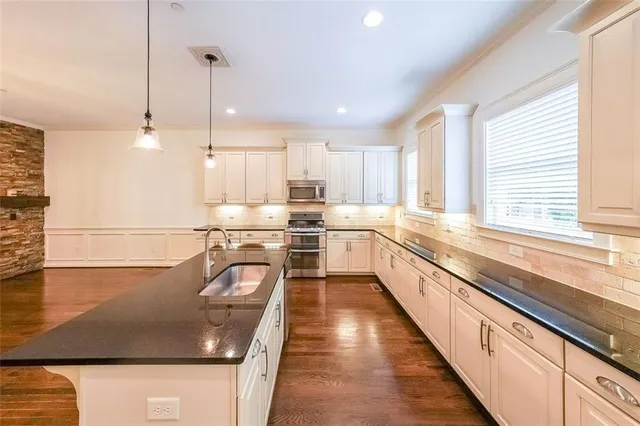 a large kitchen with kitchen island a large window