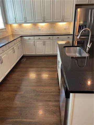 a kitchen with granite countertop a sink and a stove