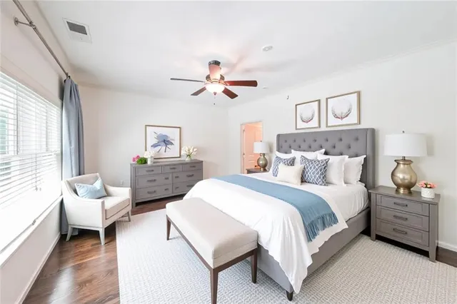 a spacious bedroom with a bed a couch and a chandelier