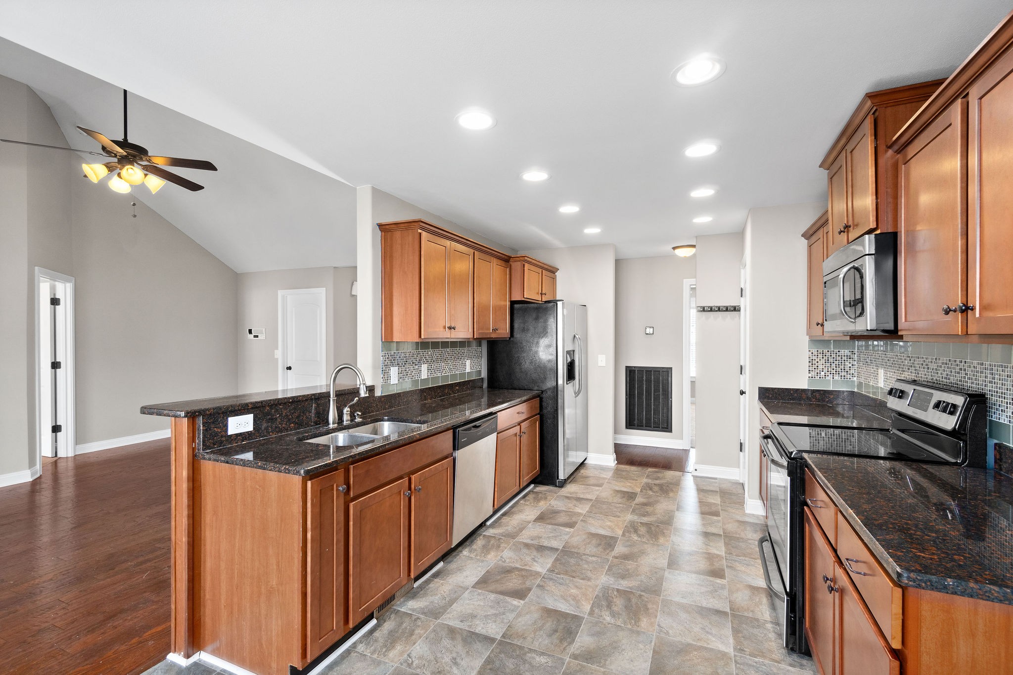 3782 Suiter Road Clarksville, TN 37040 - Photo 14 of 32 a kitchen with stainless steel appliances granite countertop a sink a stove a refrigerator cabinets and living room view
