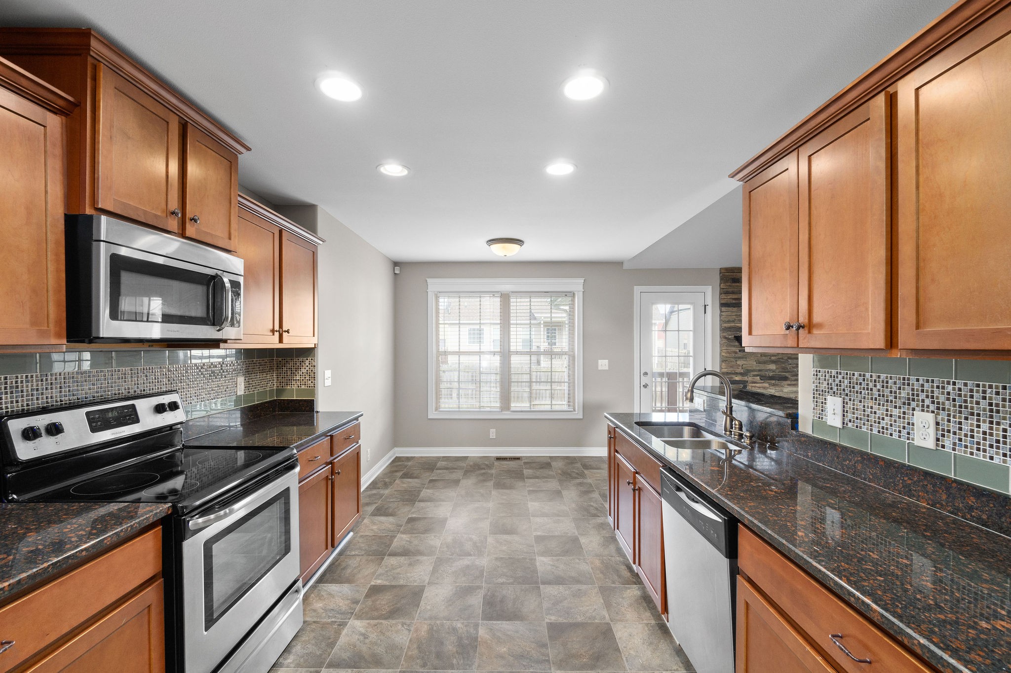 3782 Suiter Road Clarksville, TN 37040 - Photo 17 of 32 a large kitchen with stainless steel appliances granite countertop a stove top oven a sink dishwasher a microwave oven and a granite counter top