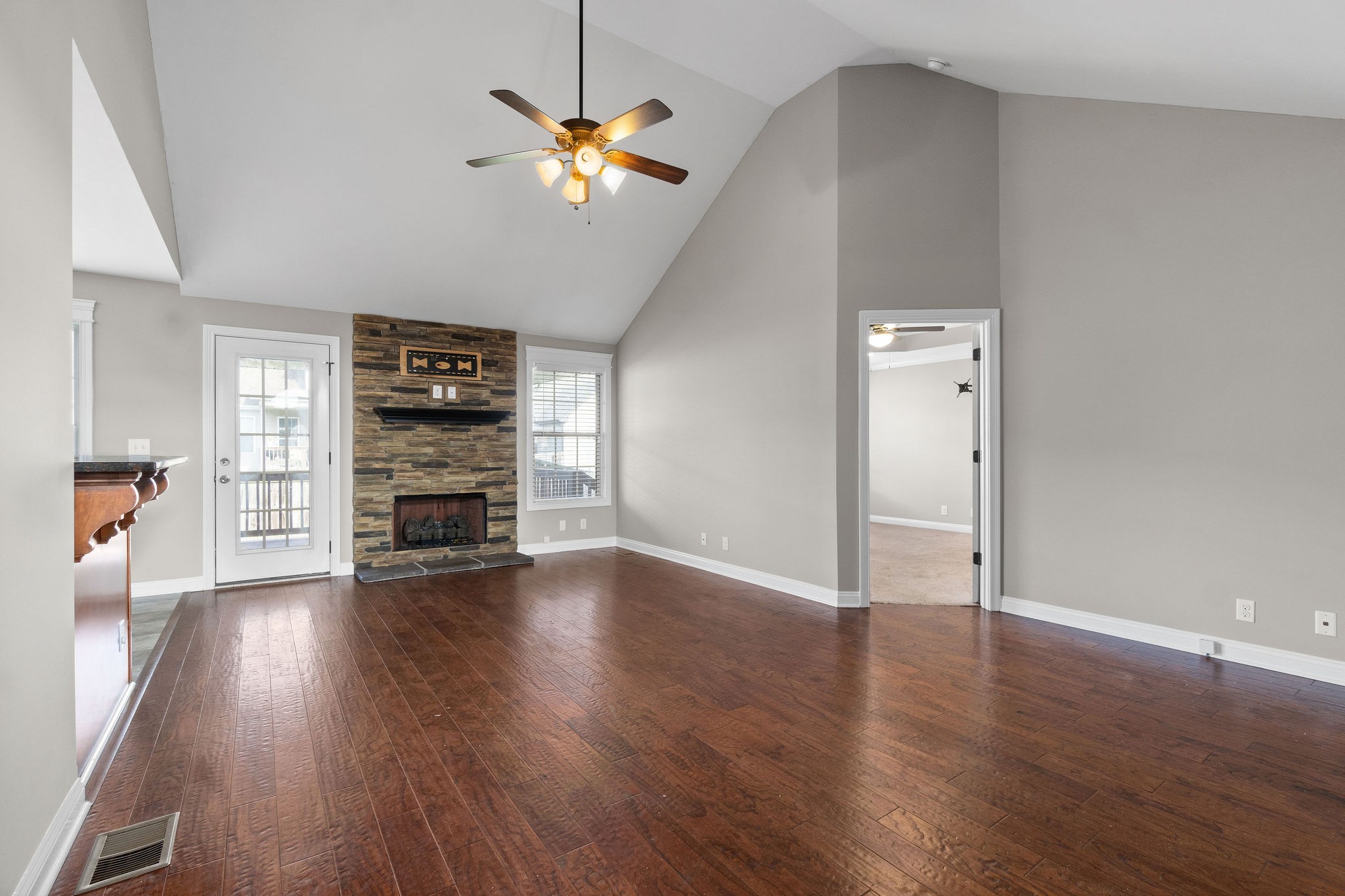 3782 Suiter Road Clarksville, TN 37040 - Photo 7 of 32 an empty room with wooden floor chandelier fan and windows