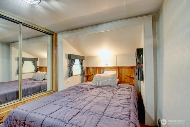 a bedroom with a large bed and a mirror