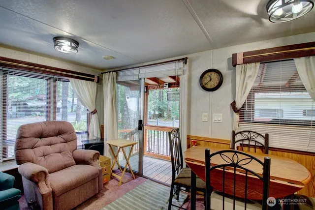 a living room with furniture a clock and a large window