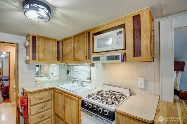 a kitchen with stainless steel appliances a stove a sink and a microwave