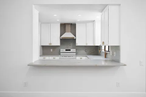 a view of kitchen with stainless steel appliances granite countertop refrigerator sink and stove