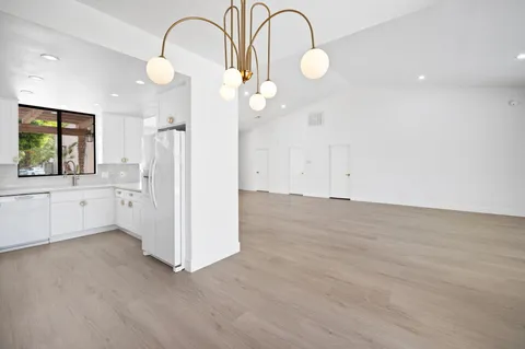 a view of a kitchen with wooden floor and window