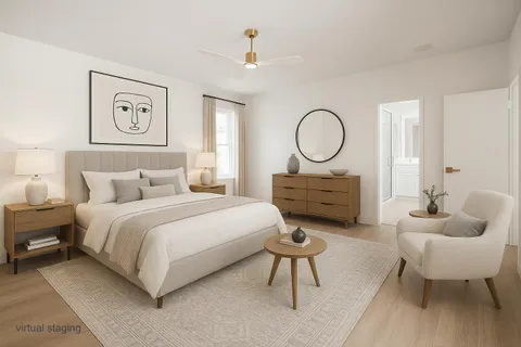 a spacious bedroom with a bed a couch and a chandelier