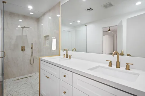 a bathroom with a sink a shower a mirror and a bathtub