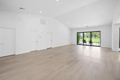 an empty room with wooden floor and window