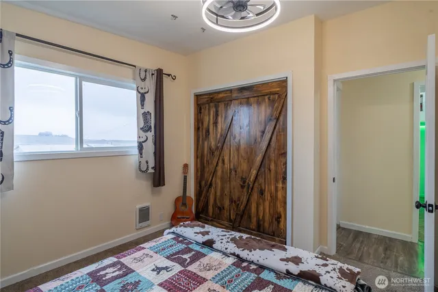 a bedroom with a bed and a painting on the wall