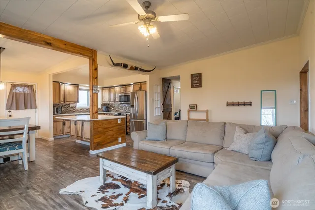 a living room with furniture and a view of kitchen