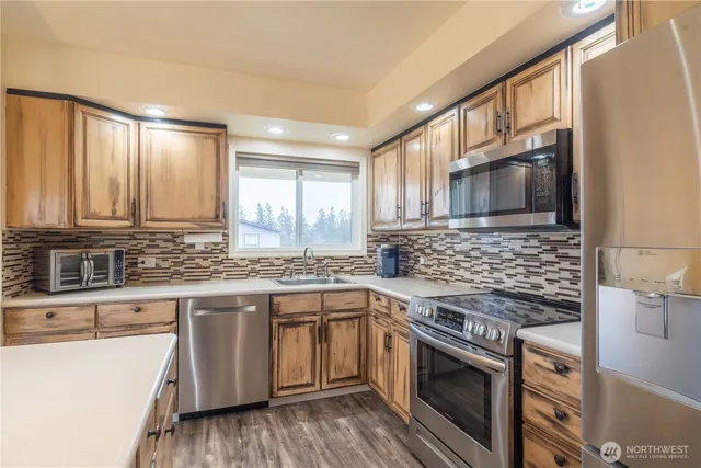 a kitchen with stainless steel appliances granite countertop a stove a sink and a microwave