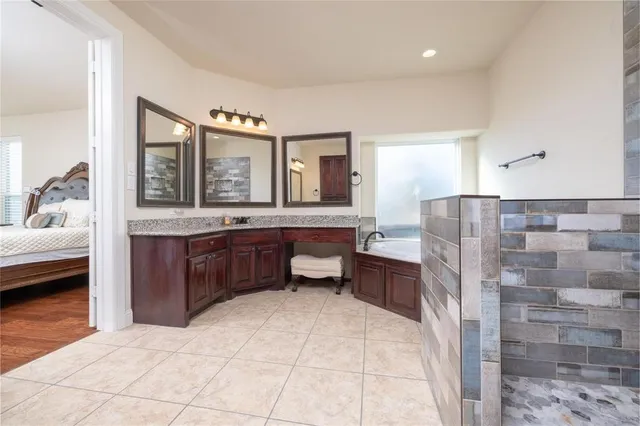 a spacious bathroom with a tub sink and mirror