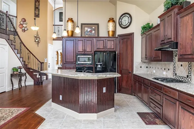 a kitchen with stainless steel appliances granite countertop a stove a sink dishwasher and cabinets with wooden floor