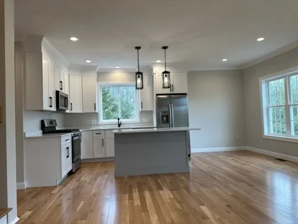 a kitchen with stainless steel appliances granite countertop a sink a stove and a wooden floors