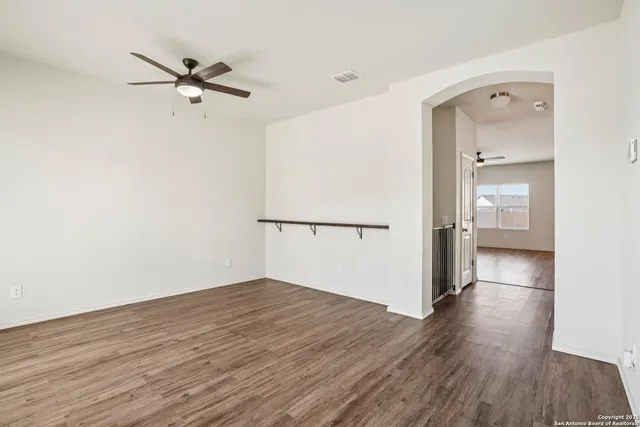 a view of a room with wooden floor and a ceiling fan