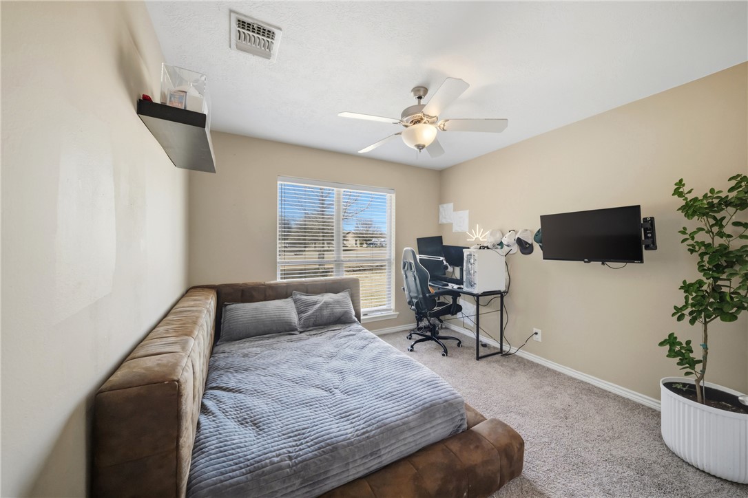 214 Apache Drive Franklin, TX 77856 - Photo 23 of 32 a bedroom with a bed and a chair with the potted plants