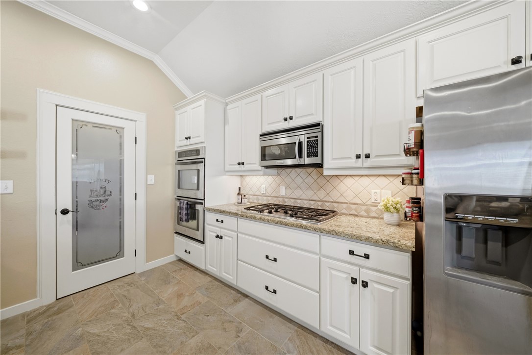 214 Apache Drive Franklin, TX 77856 - Photo 10 of 32 a kitchen with granite countertop white cabinets and stainless steel appliances