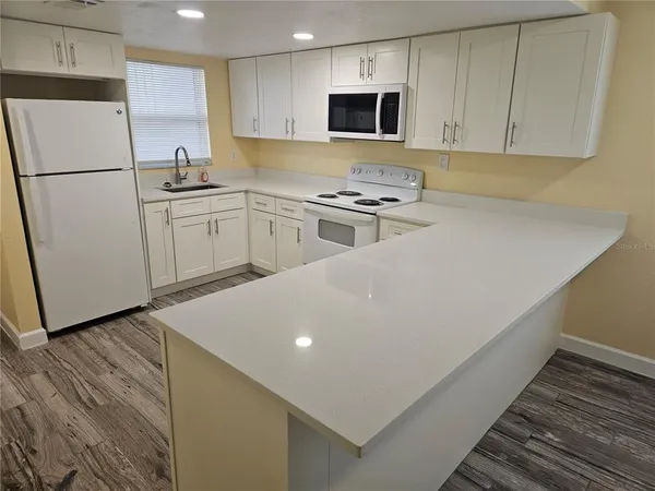 a kitchen with stainless steel appliances a refrigerator sink and white cabinets