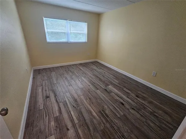 a view of a room with wooden floor and a window
