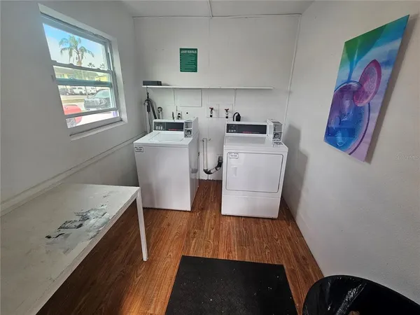 a room with wooden floor and white cabinets