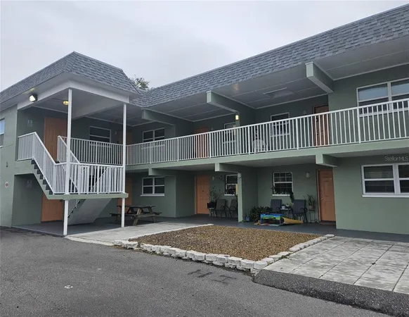 a view of a house with a patio and a yard