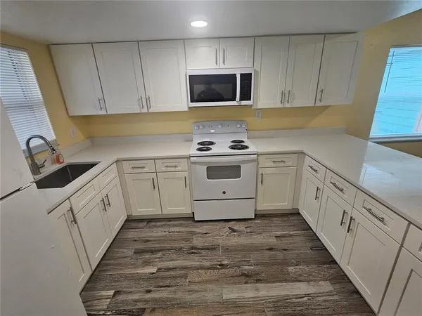 a kitchen with white cabinets appliances and a sink
