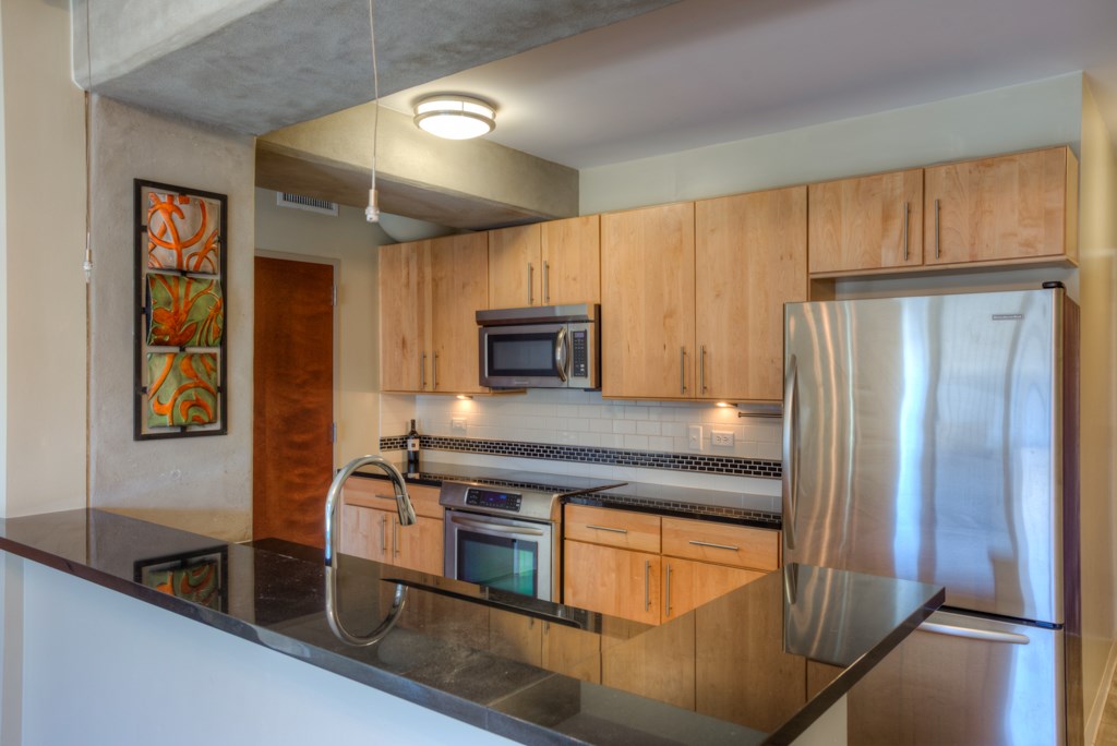 800 Brazos Street, Unit 703 Austin, TX 78701 - Photo 1 of 1 a kitchen with stainless steel appliances granite countertop a refrigerator and a sink