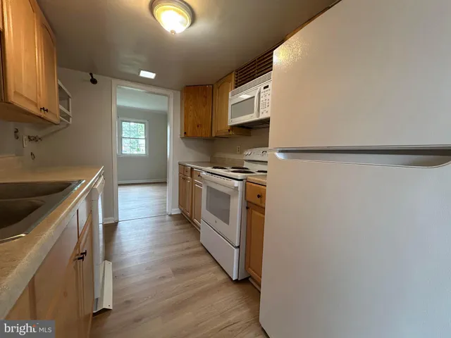 a kitchen with a sink a stove top oven and refrigerator
