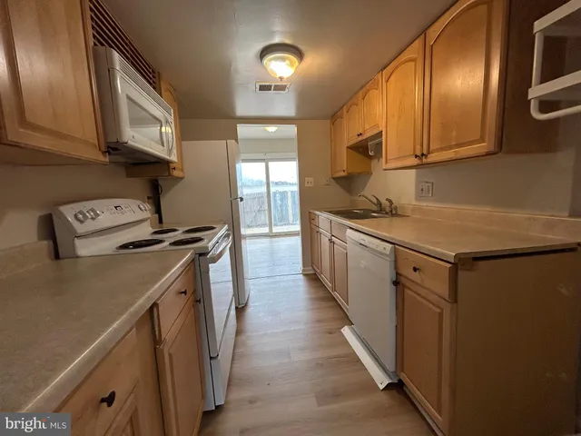 a kitchen with stainless steel appliances granite countertop a sink a stove and a wooden floors