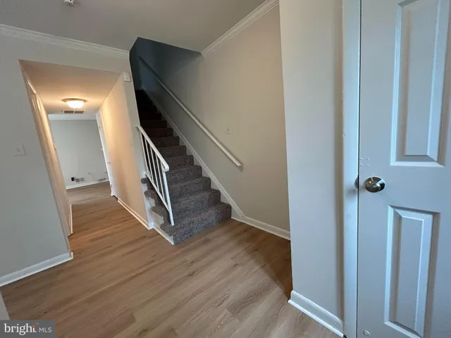a view of a hallway with wooden floor and stairs