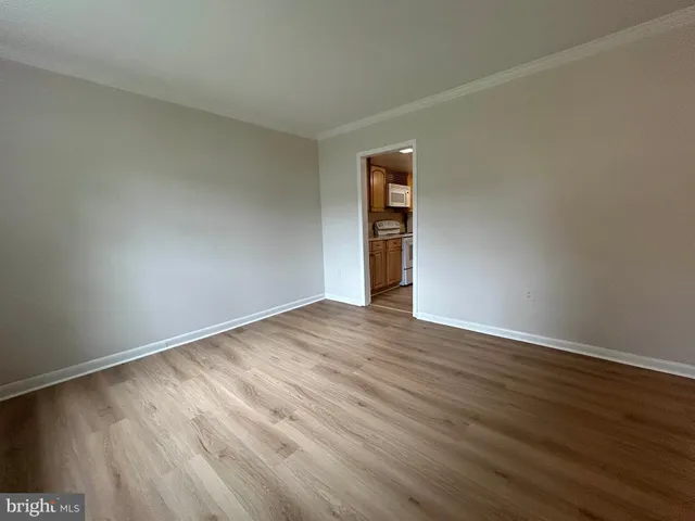 a view of an empty room with wooden floor