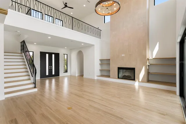a view of an empty room with wooden floor and a fireplace